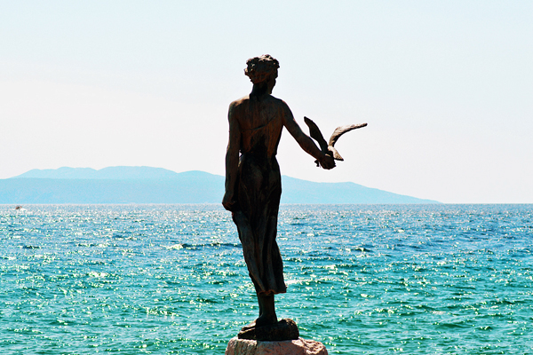 Statua della ragazza con gabbiano (Ph. M. M. - Pixabay License)