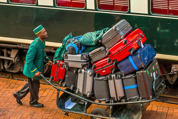 Porter loading luggage to the Rovos Rail luxury train for the journey across South Africa from Pretoria to Cape Town, Rovos Rail Station, Capital Park, Pretoria (Tshwane), South Africa.